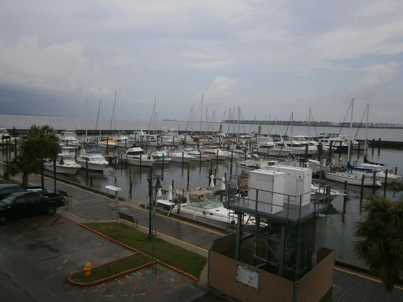 Small boats moored alongside a timber dock and gangway on sheltered water